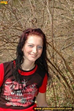 Outdoor pissing on the dry grass on a pond shore - N