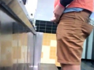 Guys in the urinals taking leak.